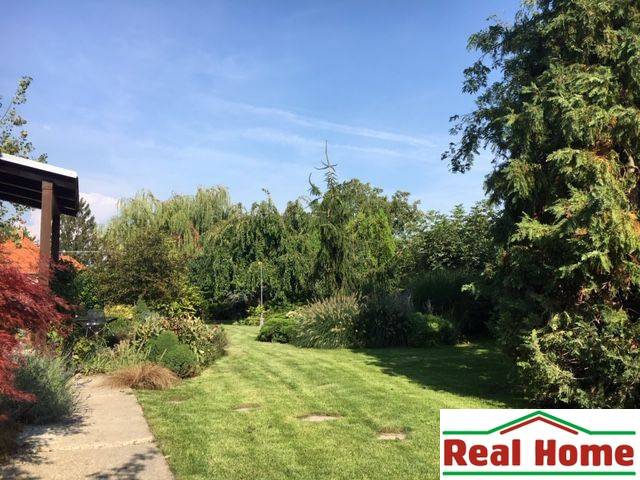 Dom s garážou na peknom rovinatom pozemku so šírkou 24m. - Záhrada pri rodinnom dome v Čiernej Vode s bohatou výsadbou a udržiavaným trávnikom.