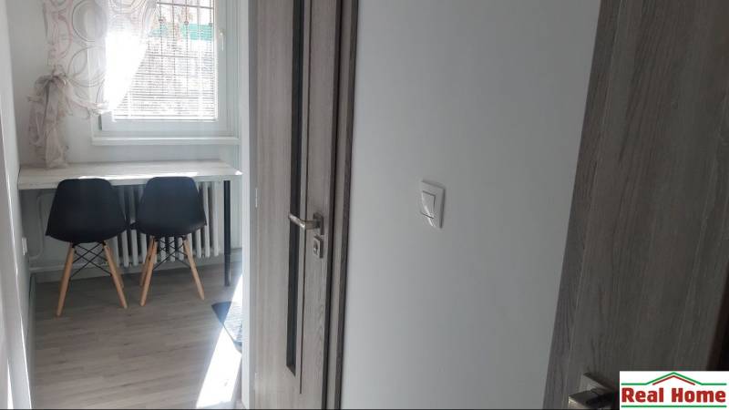 SENEC - CENTRUM - HOLLÉHO ULICA - ZARIADENÝ 1-izbový BYT - Interiér 1-izbového bytu s dverami a podlahou s dreveným dekorom.