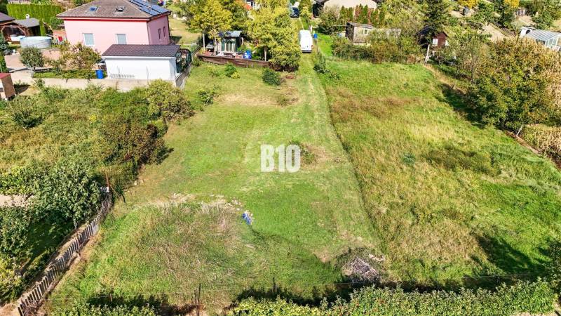 Stavebný pozemok so stavebným povolením - Janíkovce - 729 m2 - Pozemky - bývanie v Nitre s upravenou záhradou a okolitými domami.