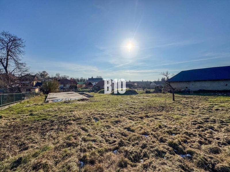 1786 m2 - základová doska - stavebné povolenie + projekt - Mojmírovce - Pozemok s betónovým základom pripravený na bývanie, slnečné počasie a okolitá krajina.