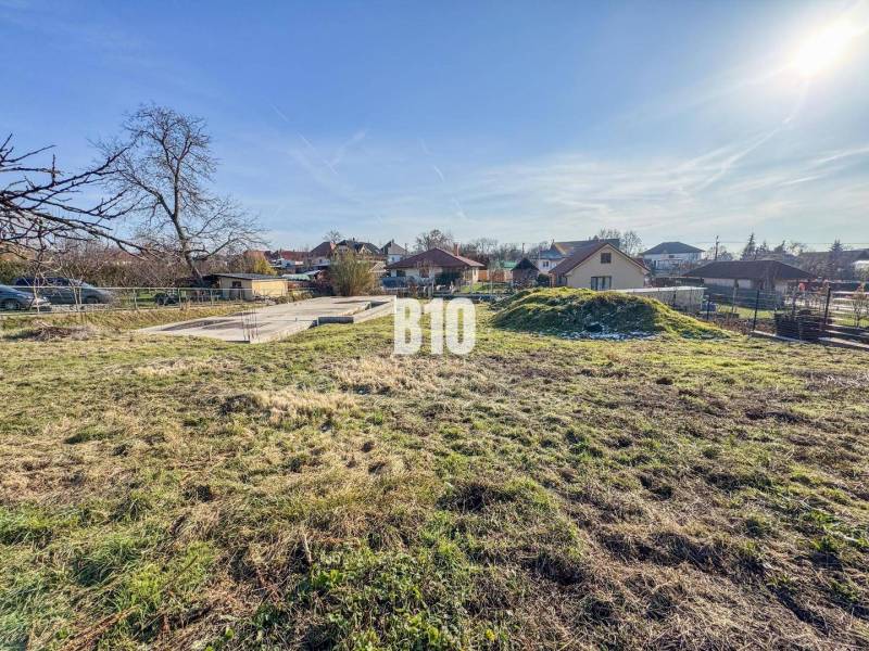 1786 m2 - základová doska - stavebné povolenie + projekt - Mojmírovce - Stavebný pozemok s trávnikom, základom domu obklopený zeleňou, ideálny pre bývanie.