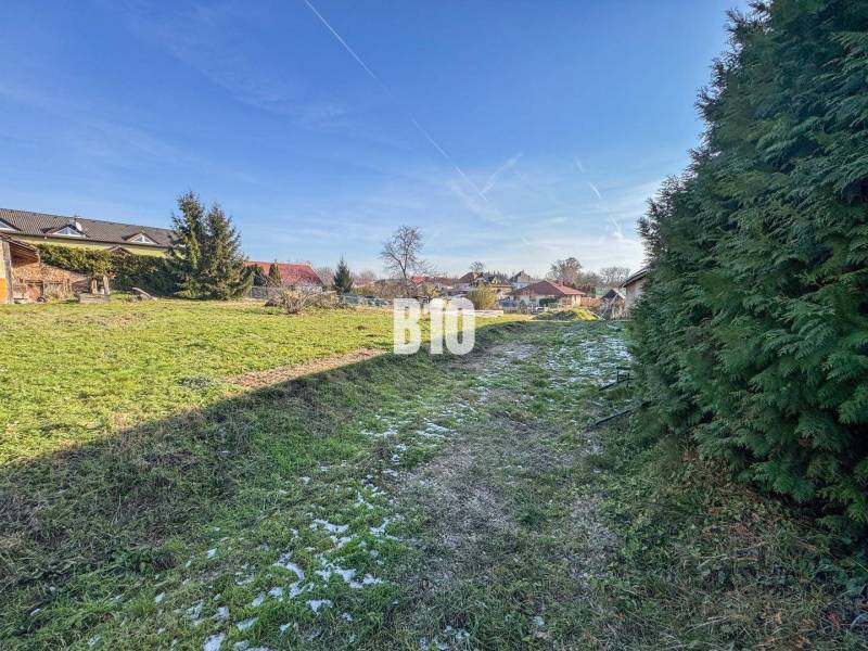 1786 m2 - základová doska - stavebné povolenie + projekt - Mojmírovce - Na obrázku vidieť zelený pozemok s domami, vhodný pre bývanie.