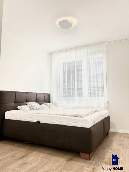PRENÁJOM exkluzívny 2 izb byt POPRAD s loggiou 53,9 + 8,34 m2 - Spálňa v 2-izbovom byte s podlahou s dreveným dekorom a pohodlnou posteľou.