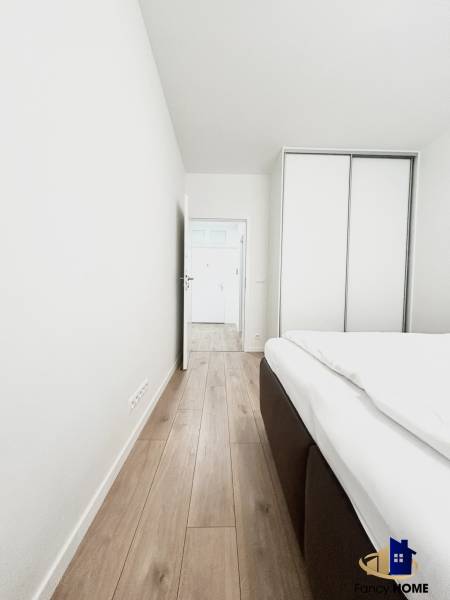 PRENÁJOM exkluzívny 2 izb byt POPRAD s loggiou 53,9 + 8,34 m2 - Izba v 2-izbovom byte s podlahou s dreveným dekorom a vstavanou skriňou.