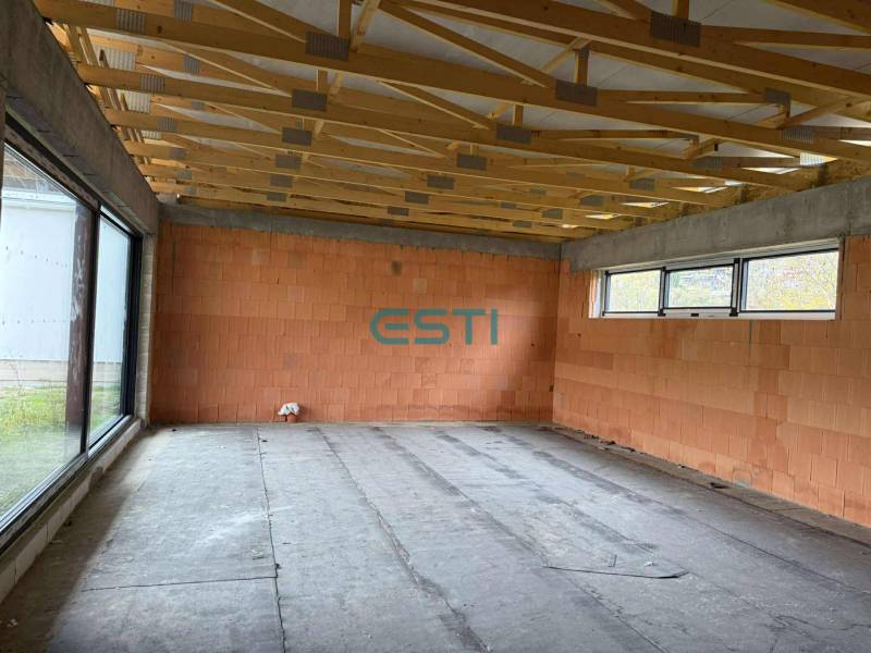 Rodinný dom - bungalov, Teplička nad Váhom - Interiér rodinného domu s veľkým oknom a stropnými trámami, prázdna miestnosť.