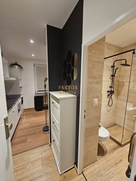 Kompletne zrekonštruovaná garsónka - BA Nové mesto - Kompaktná garsónka s podlahou s dreveným dekorom, modernou kuchyňou a dizajnovou kúpeľňou.
