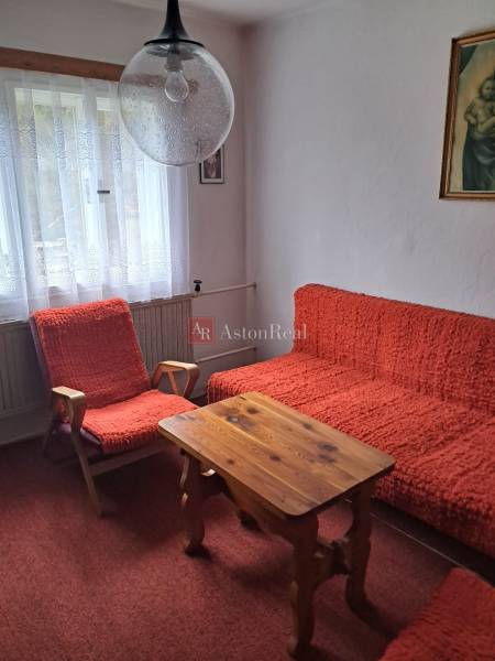 CHALUPA v rekreačnej oblasti ZÁZRIVÁ - 5km od Terchovej - Izba v rodinnom dome s červenými kreslami, stolom a záclonovými závesmi.