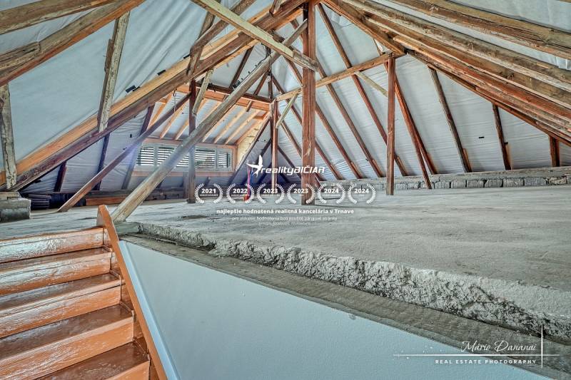 3-izbový moderne zrekonštruovaný rodinný dom v obci Jaslovské Bohunice - Povala v rodinnom dome s viditeľnými drevenými trámami a schodiskom.