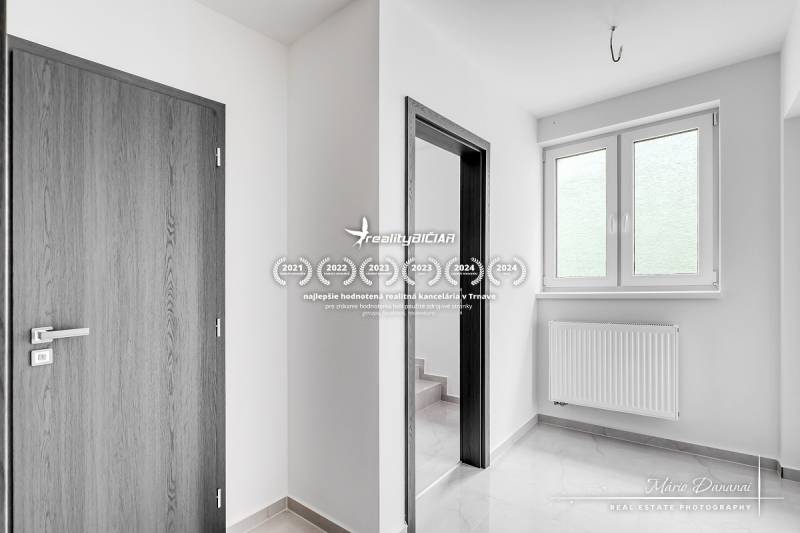 3-izbový moderne zrekonštruovaný rodinný dom v obci Jaslovské Bohunice - Interiér Rodinného domu s bielymi stenami, plastovými oknami a dverami s dreveným dekorom.