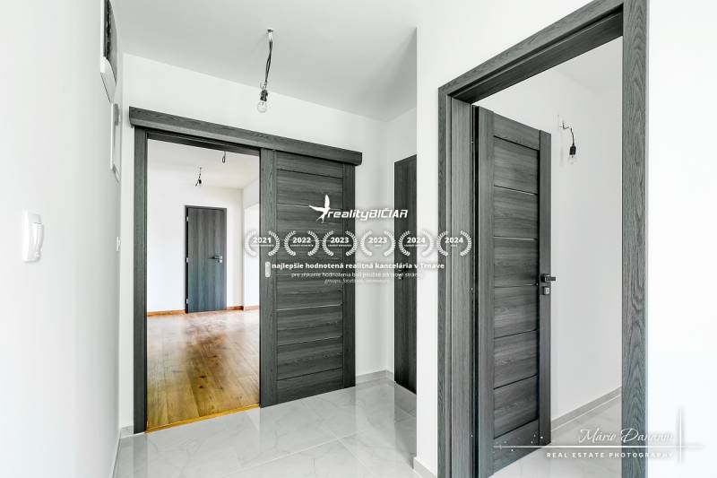 3-izbový moderne zrekonštruovaný rodinný dom v obci Jaslovské Bohunice - Interiér rodinného domu s tmavými dverami a podlahou s dreveným dekorom.