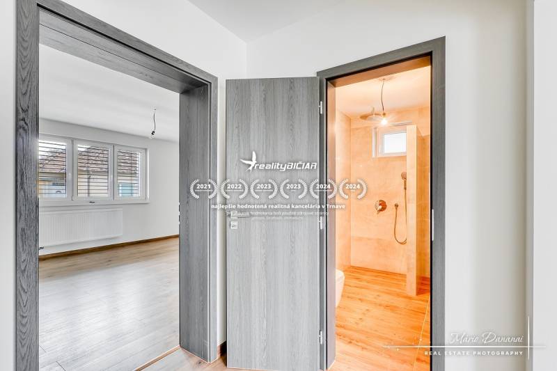 3-izbový moderne zrekonštruovaný rodinný dom v obci Jaslovské Bohunice - Interiér rodinného domu s dverami, kúpeľňou a podlahou s dreveným dekorom.