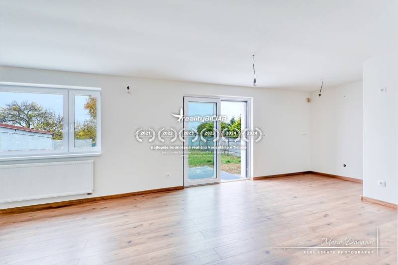 3-izbový moderne zrekonštruovaný rodinný dom v obci Jaslovské Bohunice - Svetlá miestnosť s podlahou s dreveným dekorom v rodinnom dome, veľké okná, vstup na terasu.