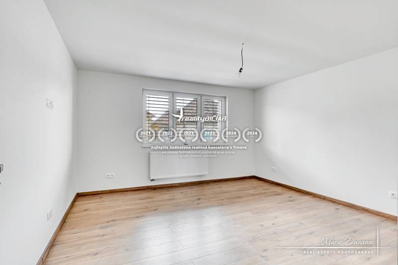 3-izbový moderne zrekonštruovaný rodinný dom v obci Jaslovské Bohunice - Izba s bielymi stenami a podlahou s dreveným dekorom v rodinnom dome.