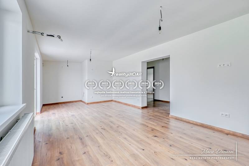 3-izbový moderne zrekonštruovaný rodinný dom v obci Jaslovské Bohunice - Priestranná miestnosť s podlahou s dreveným dekorom v rodinnom dome.