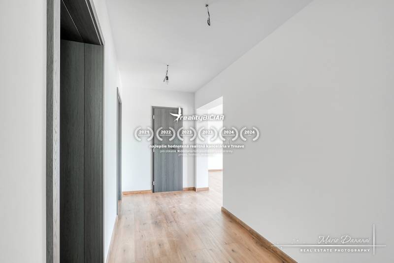 3-izbový moderne zrekonštruovaný rodinný dom v obci Jaslovské Bohunice - Chodba v rodinnom dome s podlahou s dreveným dekorom a dverami antracitovej farby.