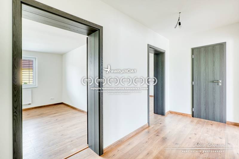 3-izbový moderne zrekonštruovaný rodinný dom v obci Jaslovské Bohunice - Rodinný dom s podlahou s dreveným dekorom, dverami a bielymi stenami.