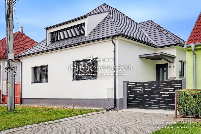 3-izbový moderne zrekonštruovaný rodinný dom v obci Jaslovské Bohunice - Rodinný dom na Orechovej ulici v Jaslovských Bohuniciach s modernou strechou a plotom.