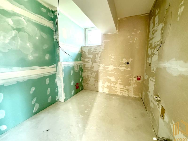 NOVÝ 2 - IZB. BYT (63m2), SENICA - SADOVÁ - Nedokončená miestnosť v 2-izbovom byte s holými stenami a oknom.