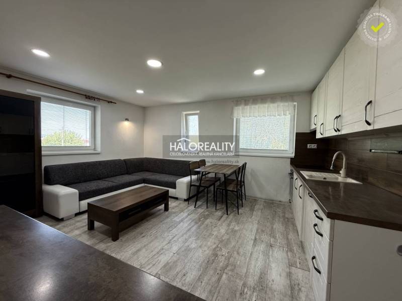 REZERVOVANÉ - Predaj, trojizbový byt Bošany - EXKLUZ... - Obývacia izba s kuchyňou, svetlá podlaha, sivá sedačka, jedálenský stôl v 3-izbovom byte.