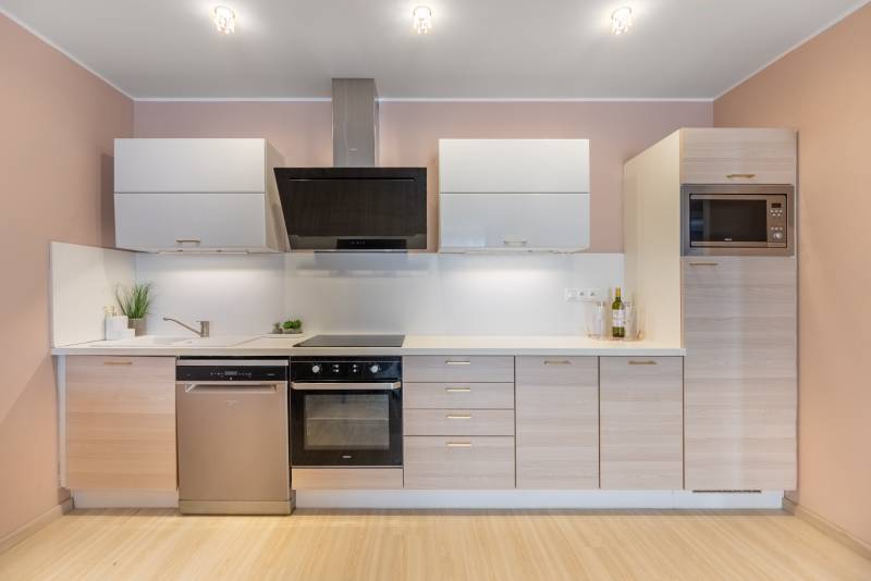 Moderný rodinný dom s bazénom v Trnave!!! - Kuchyňa v rodinnom dome s kuchynskou linkou, vstavanými spotrebičmi a podlahou s dreveným dekorom.