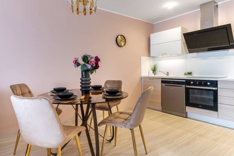 Moderný rodinný dom s bazénom v Trnave!!! - Jedáleň s okrúhlym stolom a kuchynskou linkou v rodinnom dome, podlaha s dreveným dekorom.