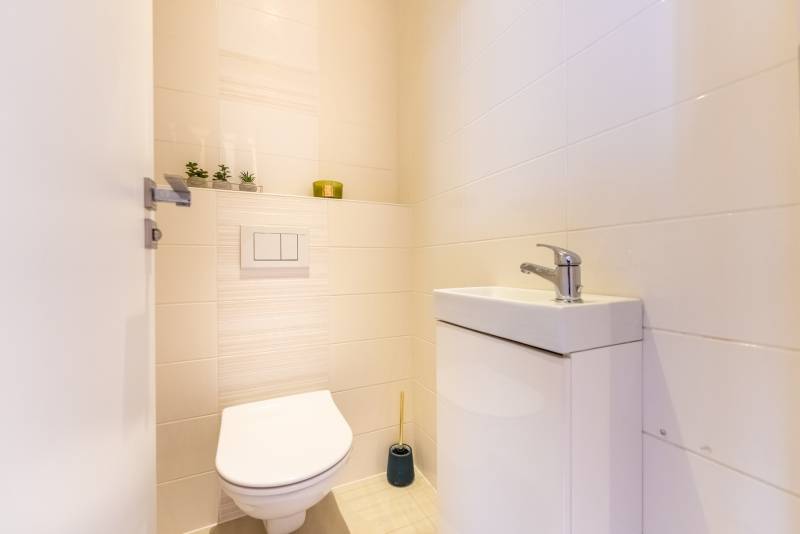 Moderný rodinný dom s bazénom v Trnave!!! - Kúpeľňa s umývadlom a toaletou v rodinnom dome, svetlé obklady, dekorácie.