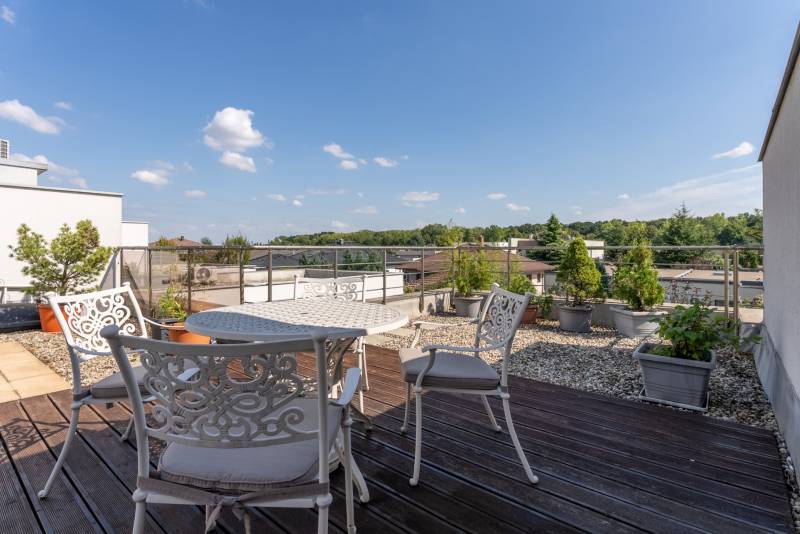 Moderný rodinný dom s bazénom v Trnave!!! - Terasa rodinného domu na Jazdeckej ulici v Trnave s kvetináčmi a sedením.