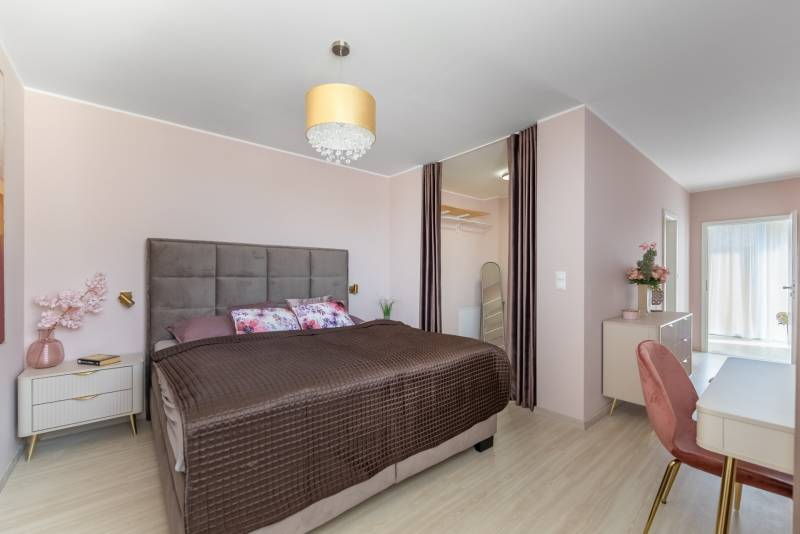 Moderný rodinný dom s bazénom v Trnave!!! - Spálňa v rodinnom dome s veľkou posteľou, šatníkom a podlahou s dreveným dekorom.