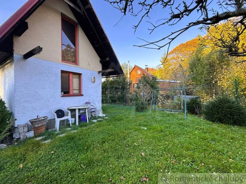 Záhrada s chatkou pod Malými Karpatami, Sološnica - Exteriér chaty v Sološnici obklopený zeleným trávnikom a stromami.