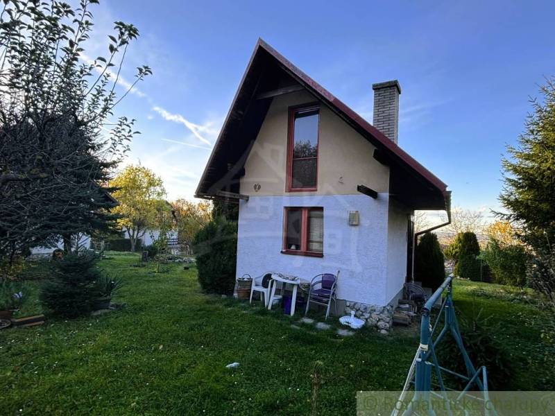 Záhrada s chatkou pod Malými Karpatami, Sološnica - Chata v Sološnici s upravenou záhradou, obklopená stromami a jasnou oblohou.