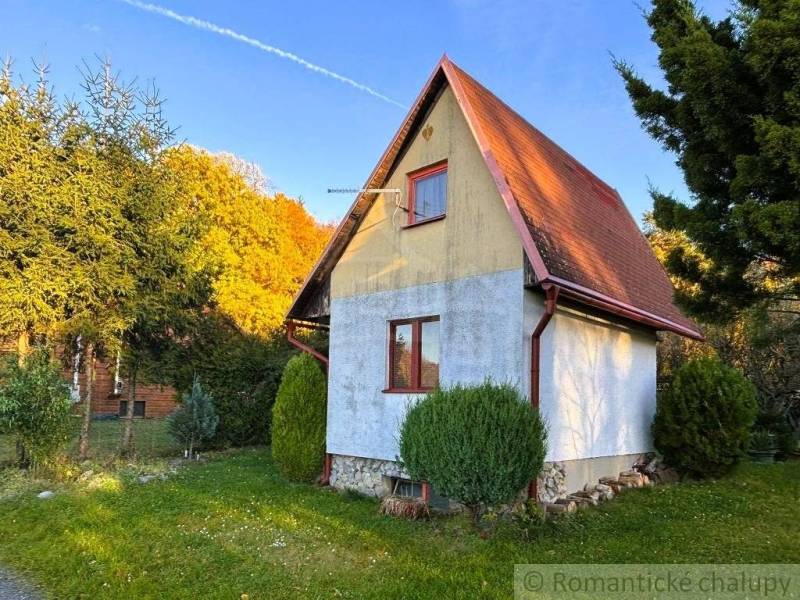 Záhrada s chatkou pod Malými Karpatami, Sološnica - Chata v Sološnici obklopená zeleňou, so sedlovou strechou a udržiavaným trávnikom.
