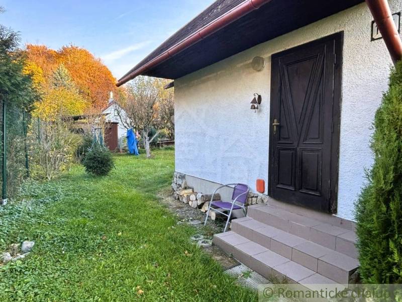 Záhrada s chatkou pod Malými Karpatami, Sološnica - Chata v Sološnici s trávnikom a stromami vo farebnej jesennej krajine.