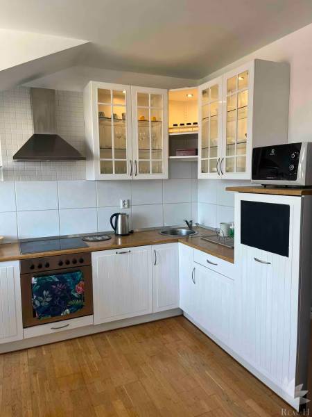 Bývanie  v Starom meste ? Jedinečná príležitosť skvelého bytu - Kuchyňa v 3-izbovom byte s drevenou podlahou, bielymi skrinkami a úložným priestorom.