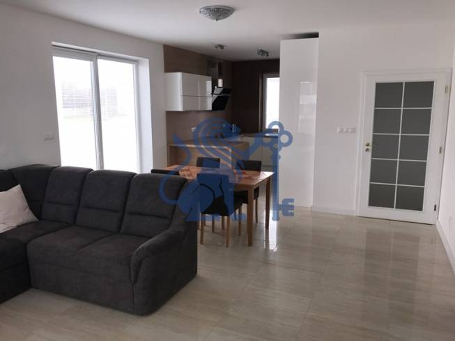 3 izbový byt, 50 m2 terasa, 2PS, Gajarská ulica, Záhorská Bystrica - Obývacia izba s pohovkou a kuchynským stolom v 3-izbovom byte.