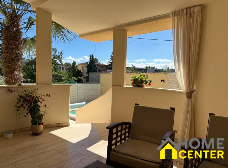 PREDAJ : ŠTÝLOVÝ RODINNÝ DOM S BAZÉNOM, KOMÁRNO - Terasa rodinného domu v Komárne s posedením a výhľadom na dvor s palmou.