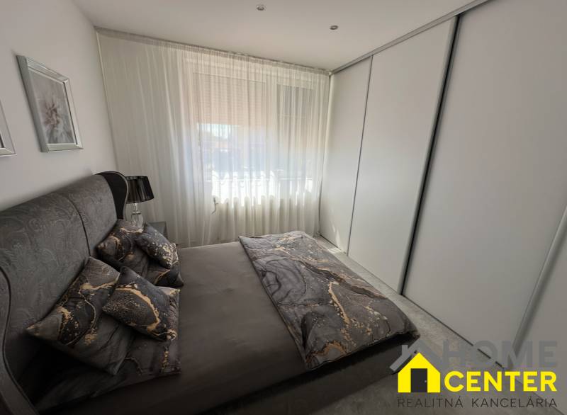 PREDAJ : ŠTÝLOVÝ RODINNÝ DOM S BAZÉNOM, KOMÁRNO - Spálňa v rodinnom dome s tmavým posteľným prádlom a veľkou skriňou.