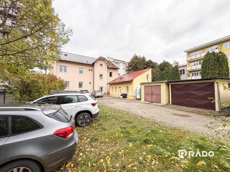 Na predaj ambulancia 101m2, Bratislavská ul. - Žilina - Parkovisko pri kanceláriách na Bratislavskej ulici v Žiline, autá a garáže v pozadí.