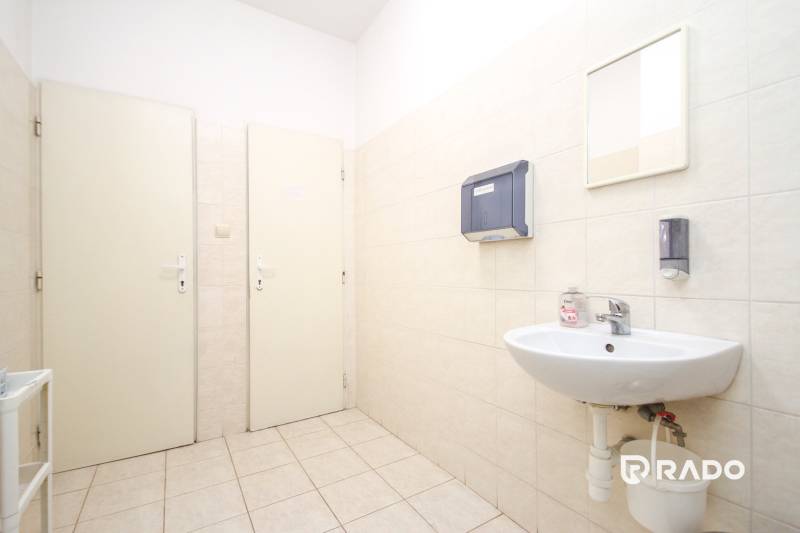 Na predaj ambulancia 101m2, Bratislavská ul. - Žilina - Kancelária s umývadlom, dávkovačmi a zrkadlom. Obklady biele, podlaha svetlá.