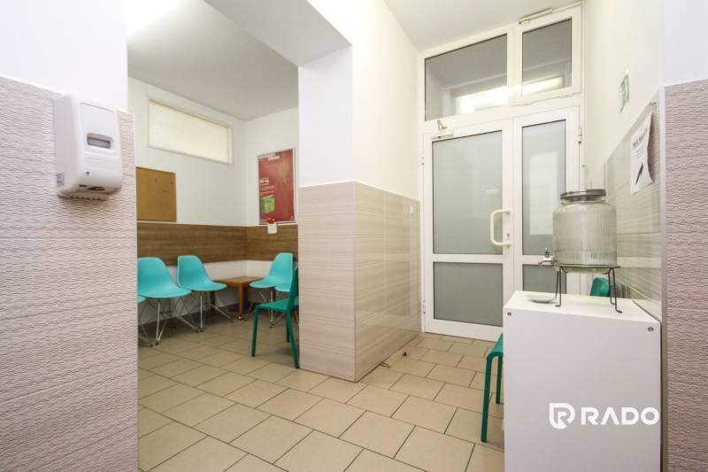 Na predaj ambulancia 101m2, Bratislavská ul. - Žilina - Čakáreň v kancelárii s tyrkysovými stoličkami a nádobou na vodu.