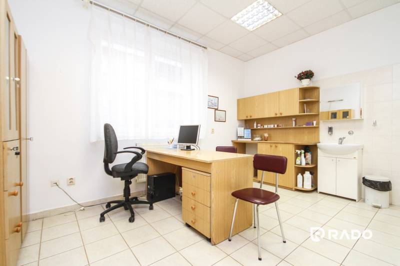 Na predaj ambulancia 101m2, Bratislavská ul. - Žilina - Kancelária s počítačom, stolom a stoličkou, svetlý interiér, poličky a umývadlo.