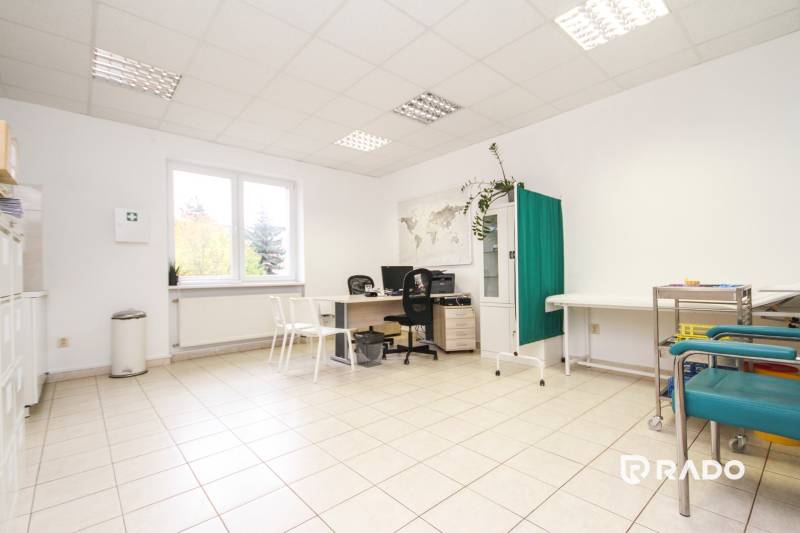 Na predaj ambulancia 101m2, Bratislavská ul. - Žilina - Svetlá kancelária s kancelárskym stolom, stoličkami, rastlinou a mapou na stene.