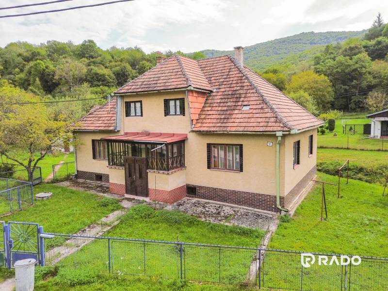 5i RD s garážou, Čierna Lehota, okr. Bánovce n./B. - Rodinný dom v Čiernej Lehote obklopený zeleňou, so šikmou strechou a záhradou.