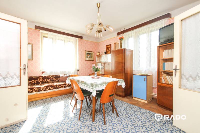 5i RD s garážou, Čierna Lehota, okr. Bánovce n./B. - Interiér rodinného domu s kobercami, drevenými stoličkami a presklenými skrinkami.