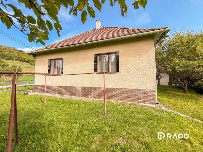 5i RD s garážou, Čierna Lehota, okr. Bánovce n./B. - Rodinný dom v Čiernej Lehote s trávnatým pozemkom a jednoduchým tehlovým dekorom.