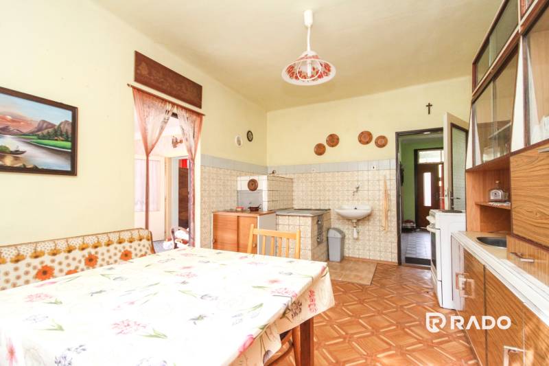 5i RD s garážou, Čierna Lehota, okr. Bánovce n./B. - Kuchyňa v rodinnom dome s dreveným dekorom, tradičný nábytok a dekorácie.