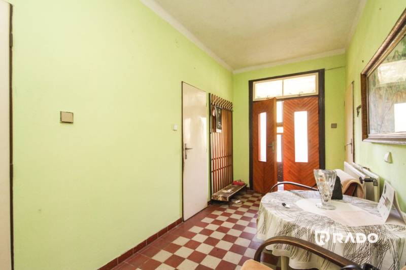 5i RD s garážou, Čierna Lehota, okr. Bánovce n./B. - Chodba rodinného domu s mintovými stenami, drevenými dverami a kockovanou podlahou.