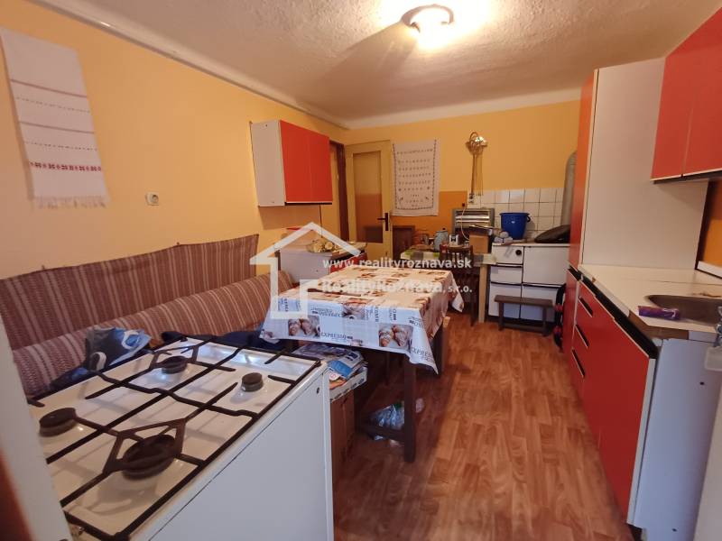 Pekný rodinný dom v obci Dlhá Ves. - Kuchyňa v rodinnom dome s plynovým sporákom a podlahou s dreveným dekorom.