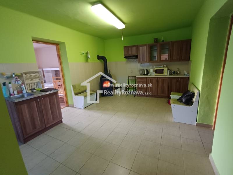 Pekný rodinný dom v obci Dlhá Ves. - Kuchyňa v rodinnom dome s dreveným dekorom, zelené steny, kachle na drevo.