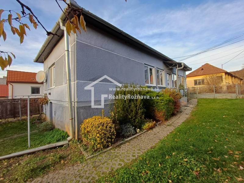 Pekný rodinný dom v obci Dlhá Ves. - Rodinný dom v Dlhej Vsi, záhrada s kríkmi, dlažba vedúca k vchodu.