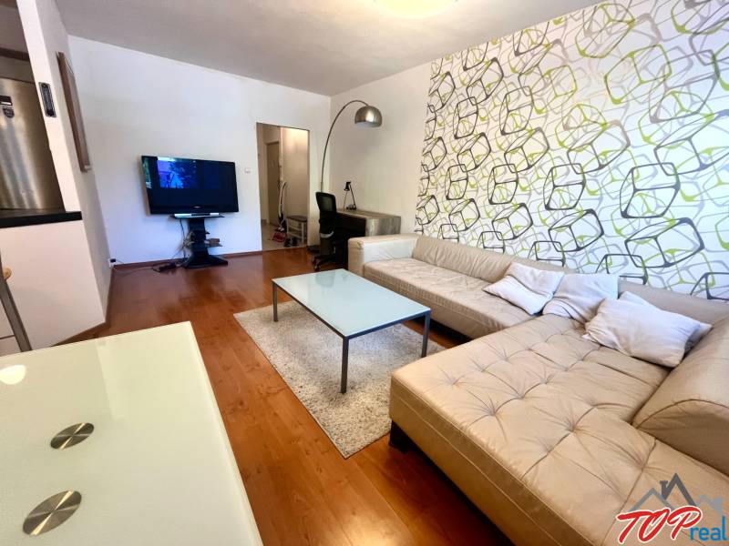 PRENÁJOM- Pekný 3 - izbový byt - Košice Staré mesto - Obývacia izba s béžovou sedačkou a televízorom v 3-izbovom byte.